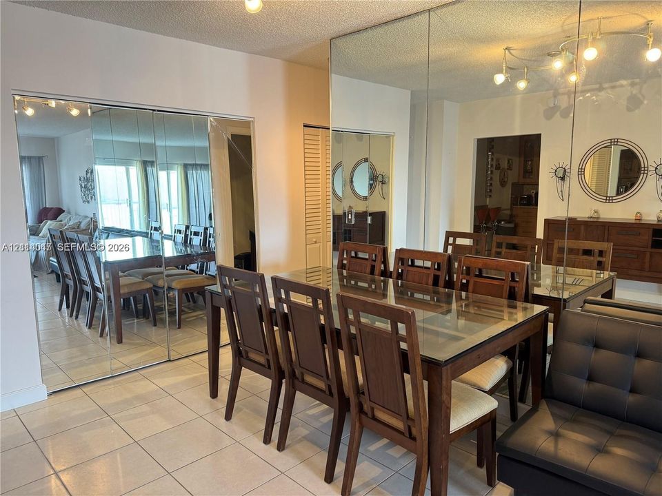 Expansive floor-to-ceiling wall mirrors, large-format tile flooring, and louvered-door built-in cabinetry