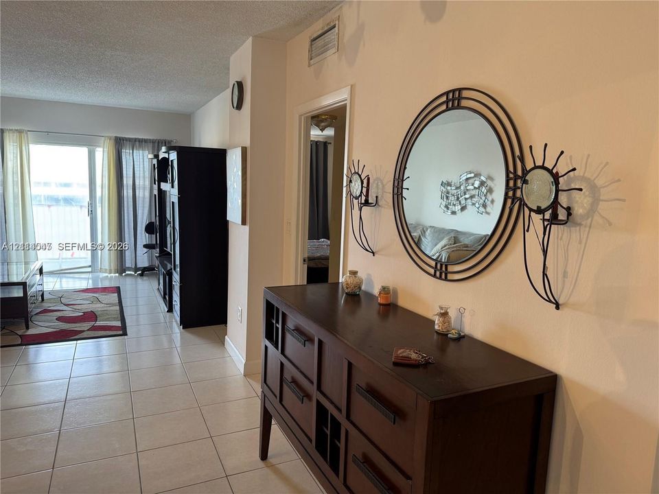 Neutral ceramic floor tiling and sliding glass doors featuring exterior access