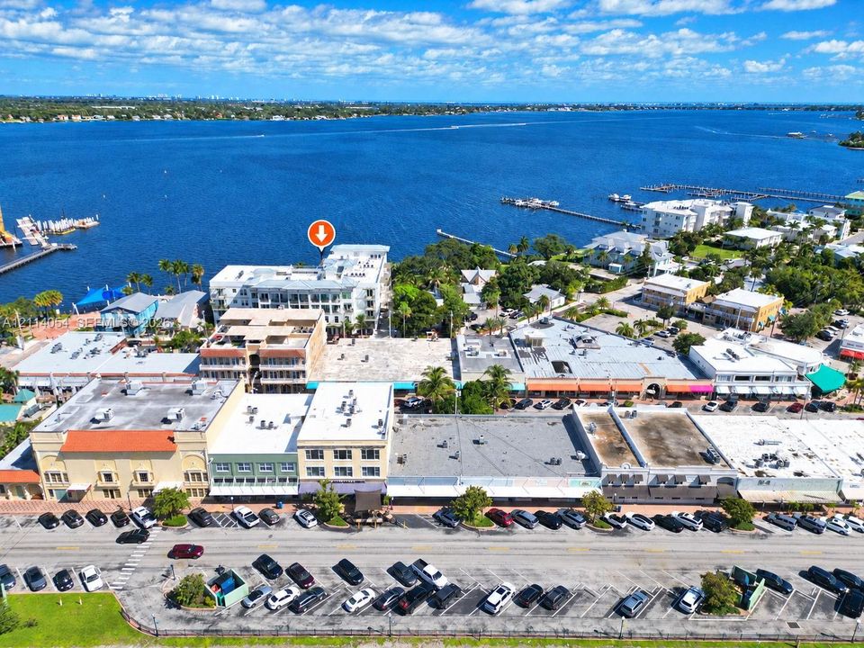 Aerial perspective of waterfront property featuring multi-story building architecture, direct proximity to open water, and localized street-level parking