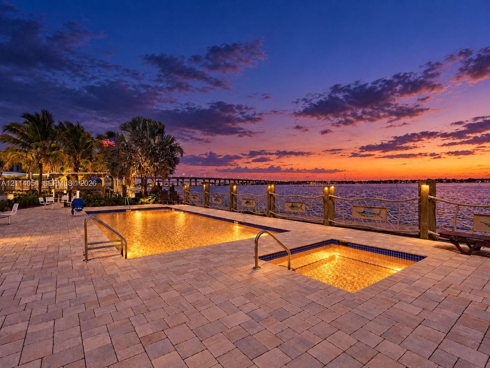 Paver patio featuring a swimming pool, integrated spa, and nautical-inspired wood post railing with rope accents