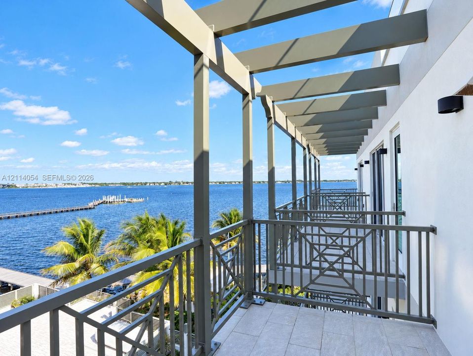 Covered balcony featuring a structural pergola, geometric metal railings, and tile flooring