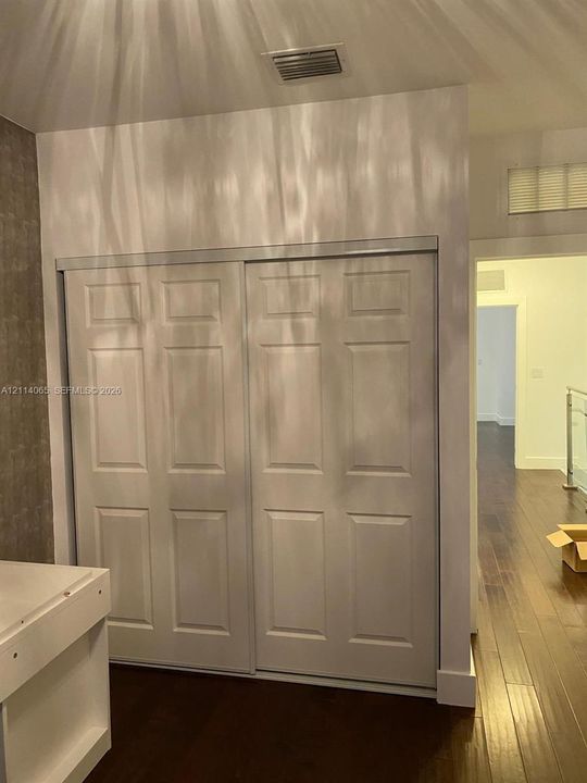 Six-panel sliding closet doors and wood-finish flooring