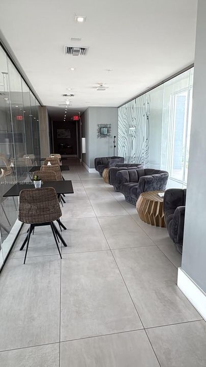Large-format floor tiling, floor-to-ceiling glass wall partitions, and recessed ceiling lighting