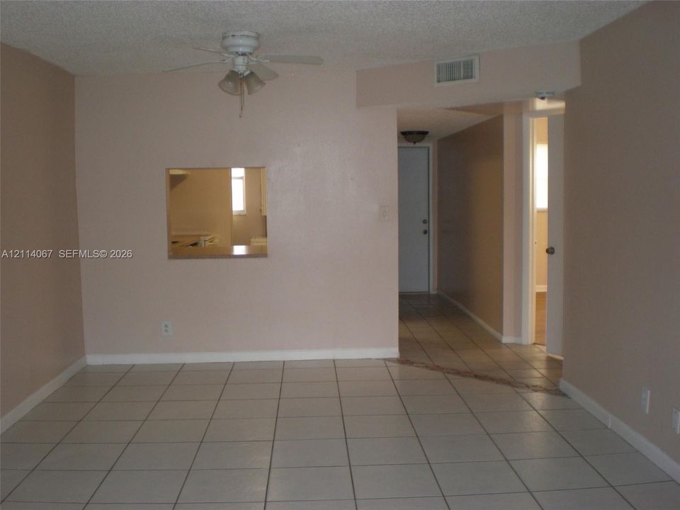 Ceramic tile flooring, built-in ceiling fan with integrated lighting, and a pass-through wall cutout