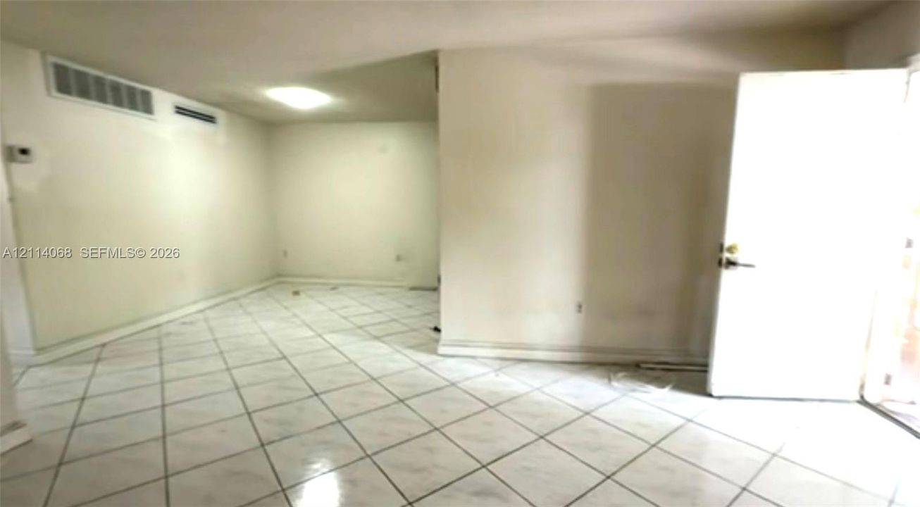 Interior space featuring white tile flooring and neutral-toned wall paint