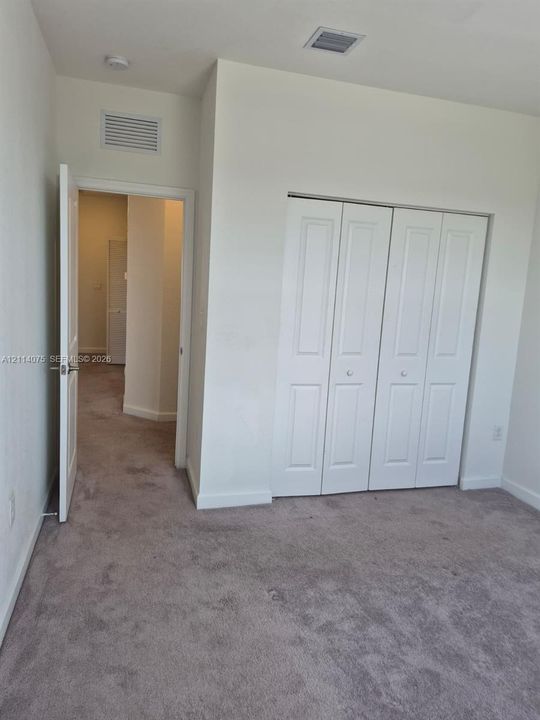 Neutral-toned carpeting throughout with white multi-panel bi-fold closet doors and interior swing door