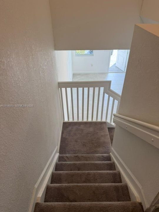 Staircase featuring wall-to-wall carpeting, a white wood railing, and painted walls