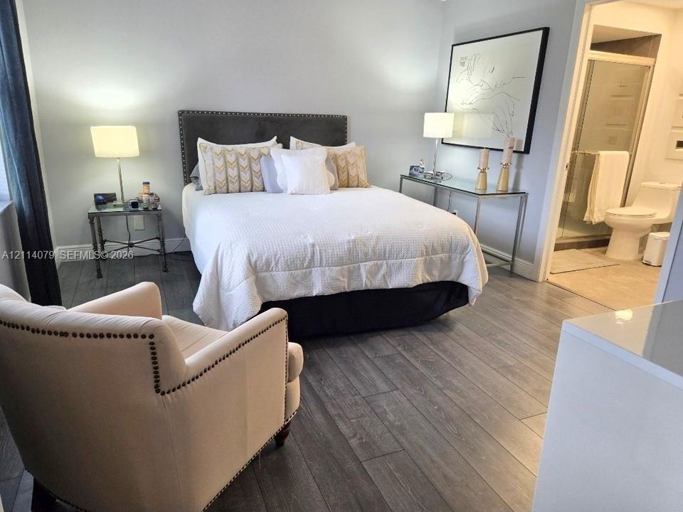 Wood-finish flooring, glass-enclosed shower, and neutral wall color palette