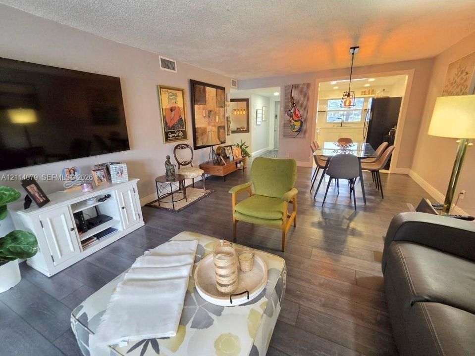 Open concept interior featuring grey wood-finish flooring, recessed lighting, and a modern pendant light fixture