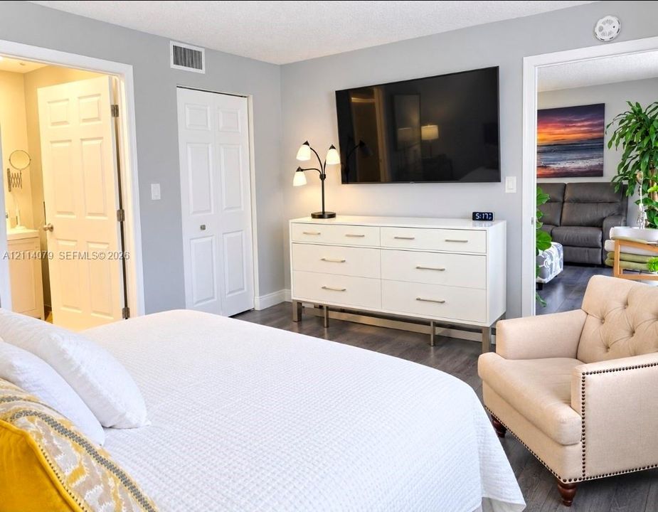 Neutral wall paint, wood-finish flooring, and white paneled interior doors