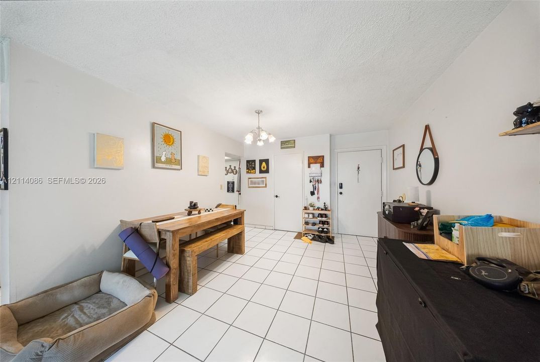 Neutral-tone interior featuring white ceramic tile flooring and a multi-arm chandelier