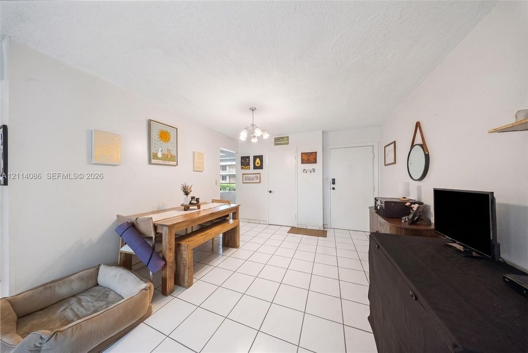 Interior space featuring white tile flooring, neutral walls, and a multi-bulb flush-mount ceiling light fixture
