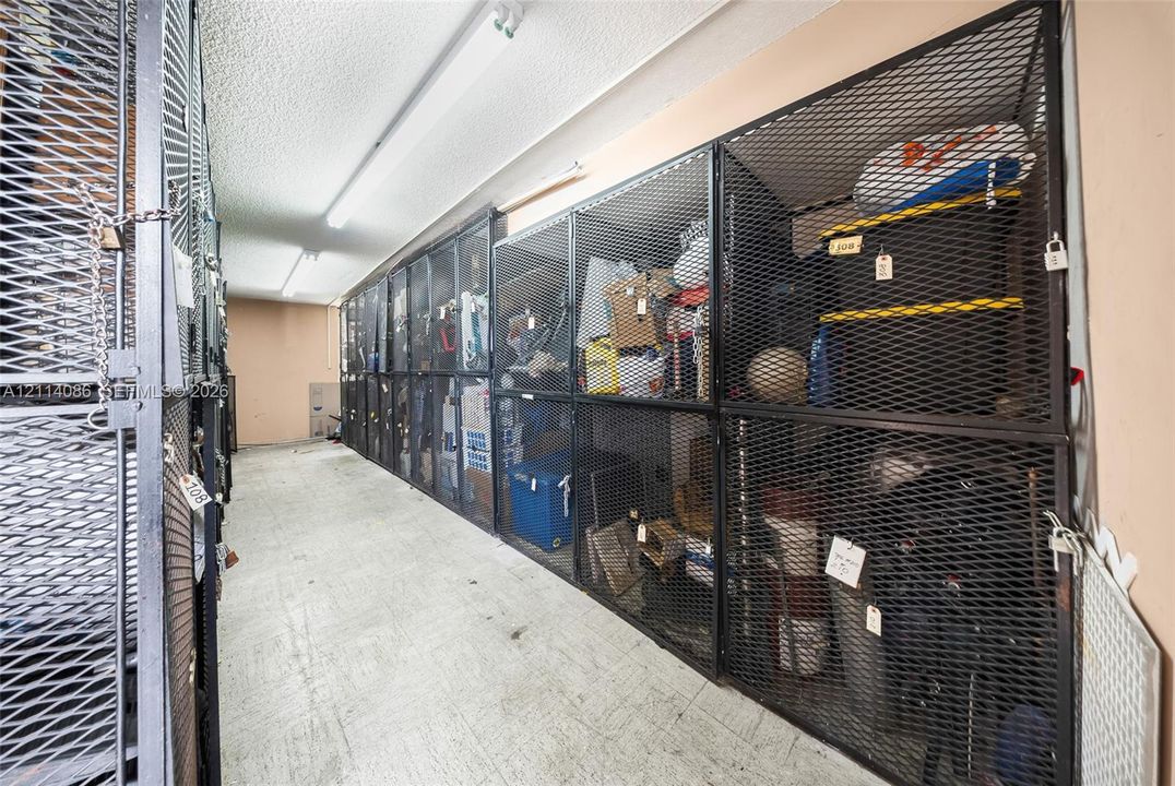 Dedicated storage room featuring floor-to-ceiling metal mesh enclosures and linear fluorescent lighting