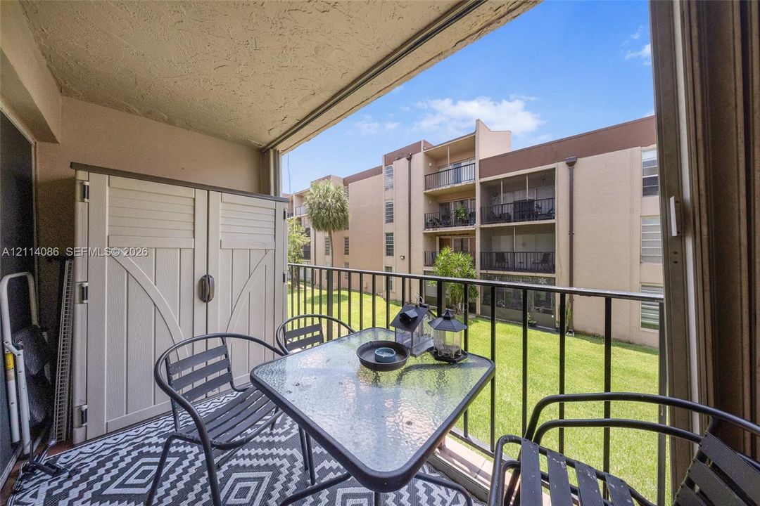Covered balcony featuring a metal railing and built-in storage unit