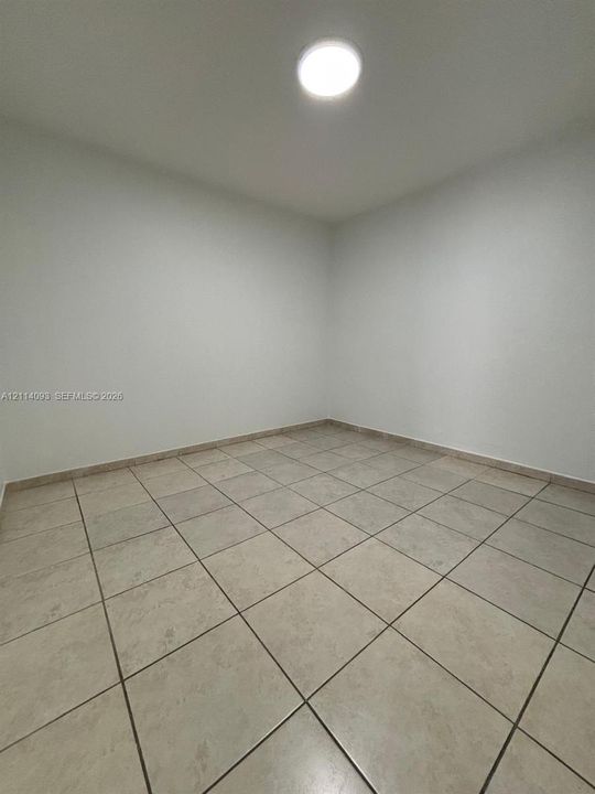 Interior space featuring neutral wall paint, ceramic floor tiling, and a flush-mount ceiling light fixture