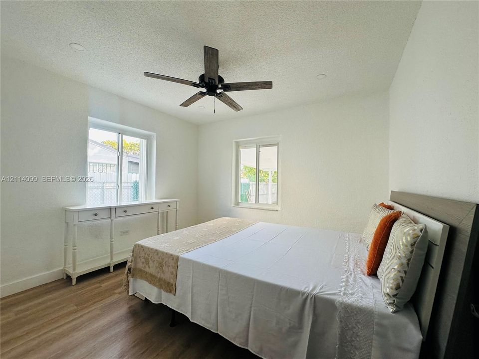 Wood-finish flooring, recessed lighting, multi-blade ceiling fan, and dual single-hung windows