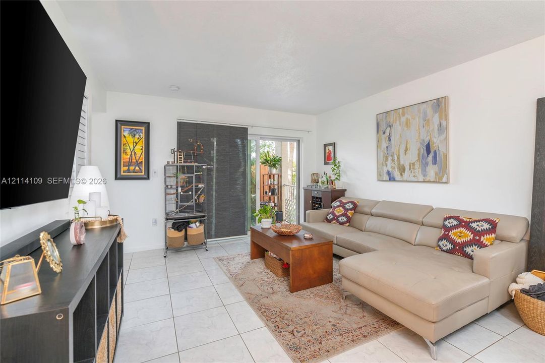 Living space featuring neutral ceramic tile flooring and a sliding glass door providing external access