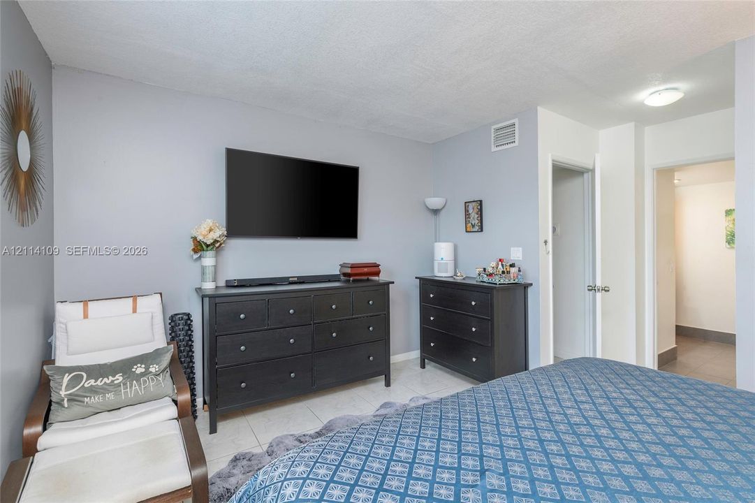 Neutral wall tones, overhead flush-mount lighting, and light-toned tile flooring