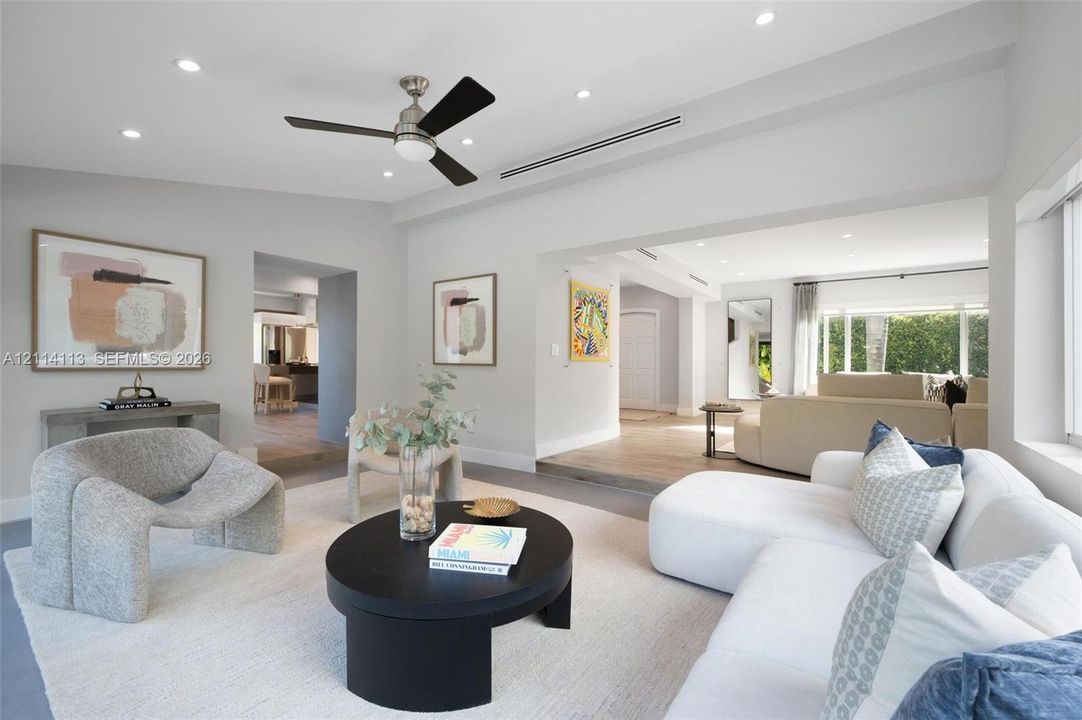 Neutral-toned interior featuring recessed lighting, a brushed-nickel ceiling fan, wood-finish flooring, and recessed linear HVAC diffusers