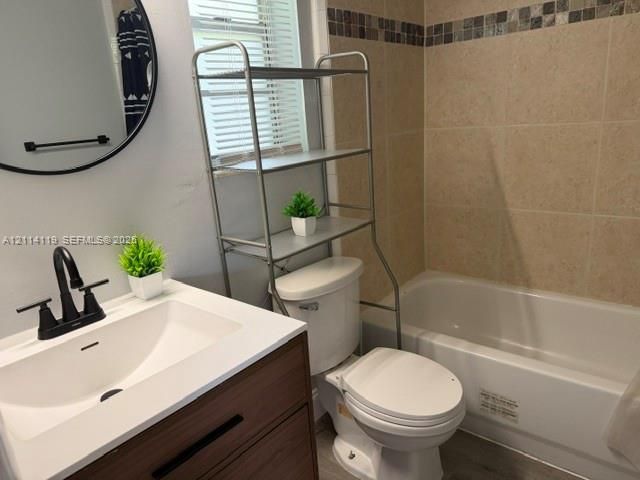 Bathroom featuring a vanity with a white rectangular sink, matte black faucet, and wood-finish cabinetry