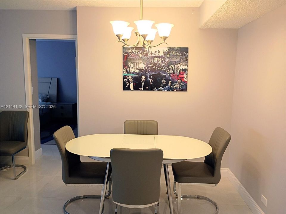 Dining area featuring light-toned tile flooring and a multi-arm chandelier with frosted glass shades