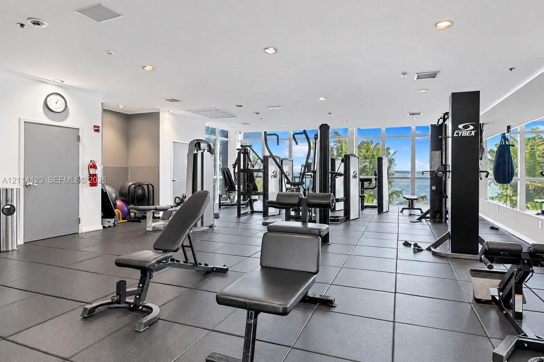 Fitness center featuring floor-to-ceiling windows, rubberized flooring, and recessed ceiling lighting