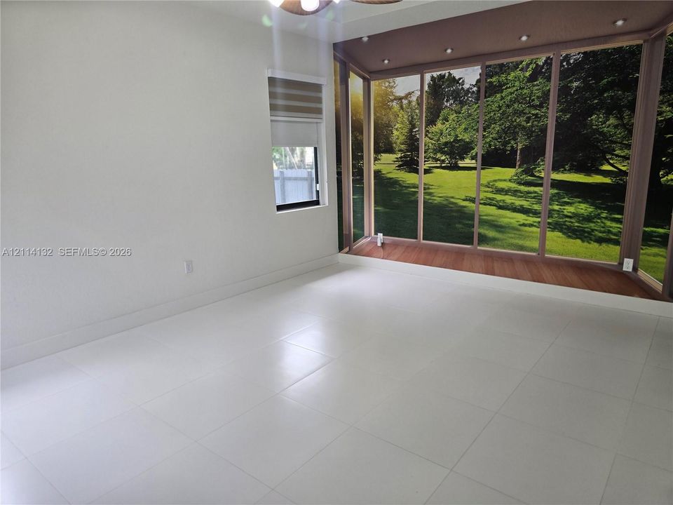 Large-format tile flooring, expansive glass-enclosed sunroom with wood-finish flooring, recessed lighting, and integrated window treatments