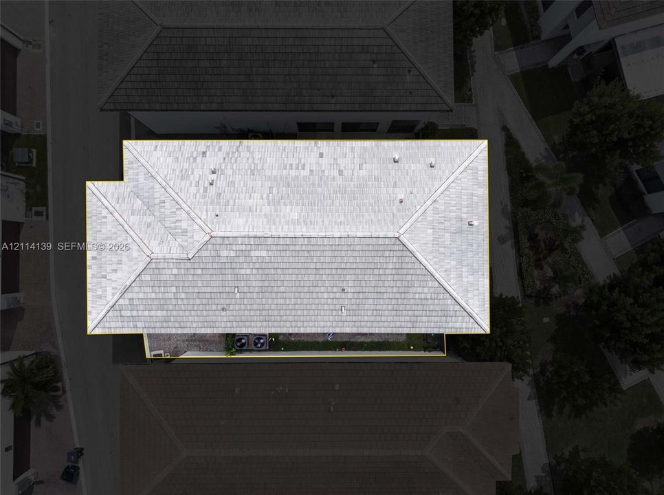 Aerial perspective of a multi-faceted roof structure featuring light-toned tile finish and external HVAC equipment