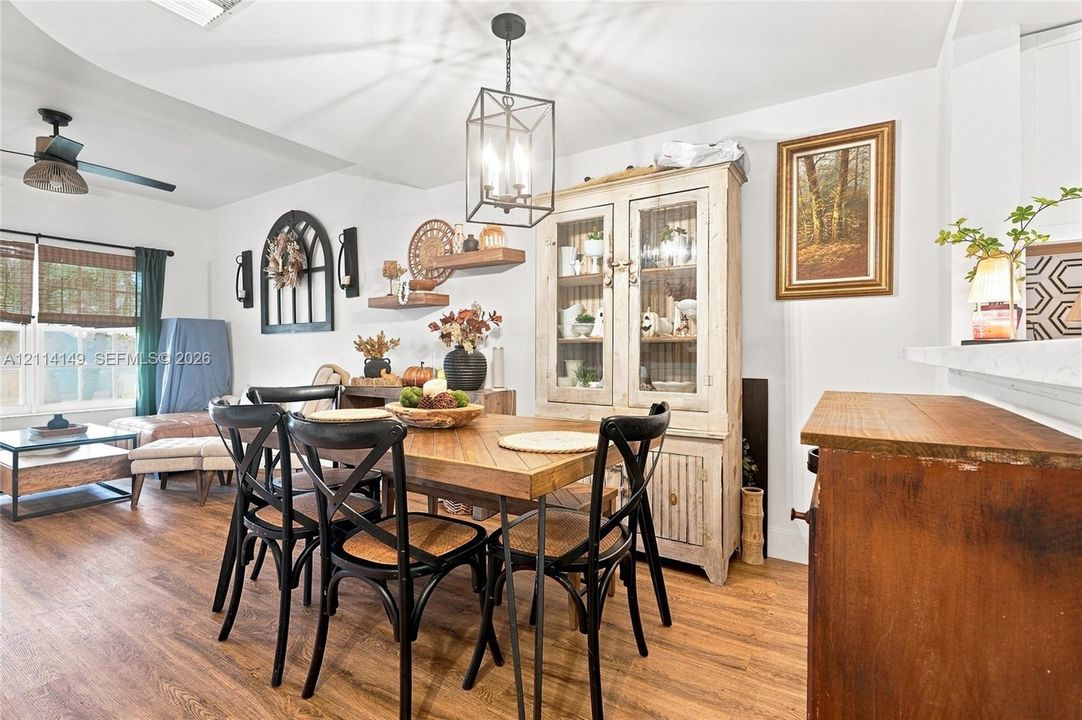 Wood-finish flooring, geometric-style metal pendant lighting, and multi-pane windows