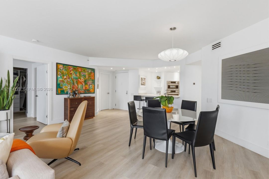 Open-concept interior featuring light-toned wood-finish flooring, recessed lighting, and a modern pendant fixture