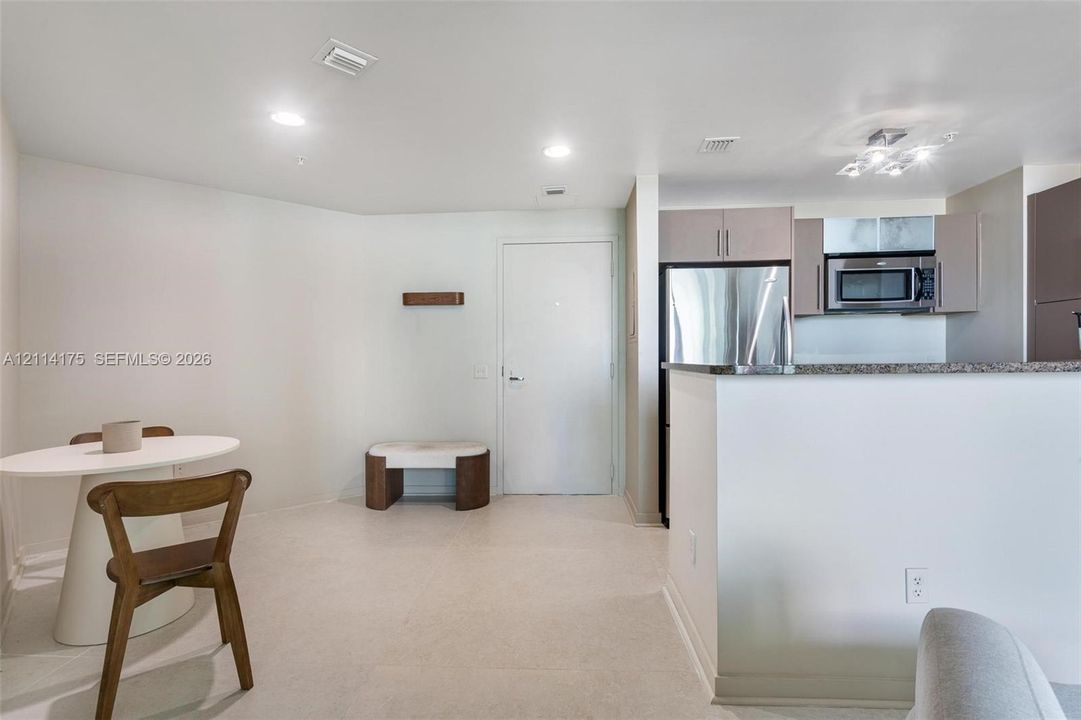 Kitchen featuring stainless steel appliances, flat-panel cabinetry, a stone-composite countertop, and recessed lighting
