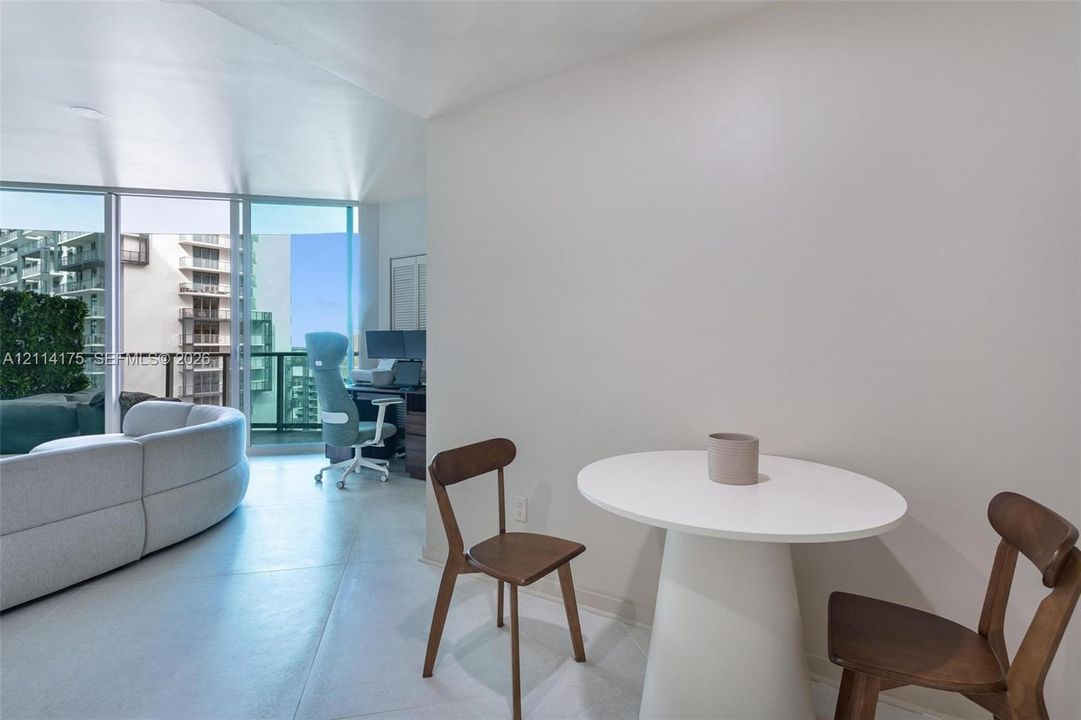 Floor-to-ceiling windows with balcony access and neutral hard-surface flooring