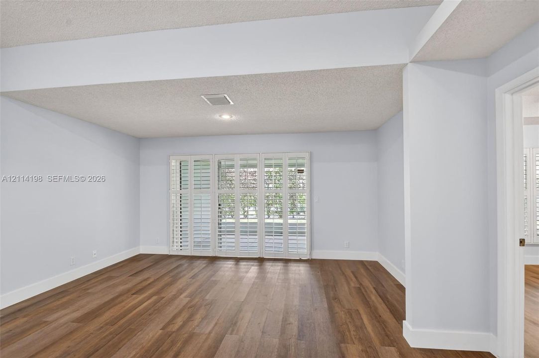 Interior room featuring wood-finish flooring, recessed lighting, and multi-panel folding shutters