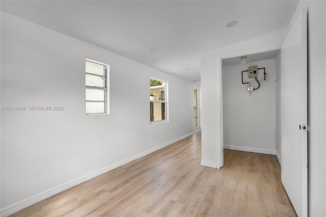 Neutral interior featuring wood-finish flooring, recessed lighting, and multiple windows
