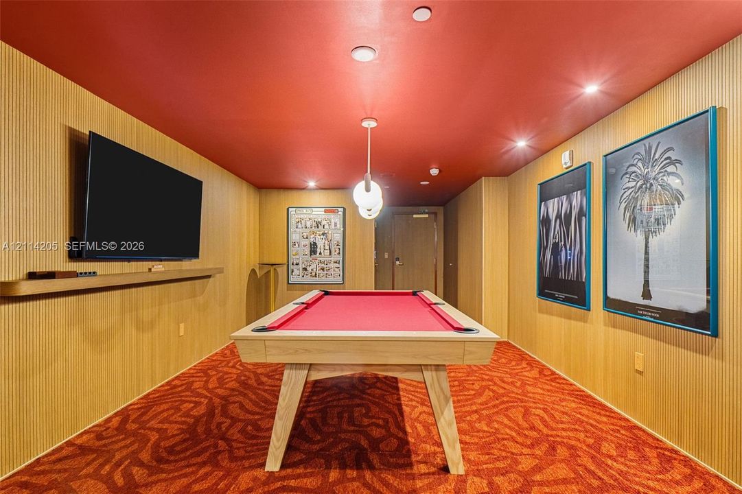 Vertical wood-paneled walls, bold red ceiling, recessed lighting, modern globe pendant fixture, and integrated wall-mounted shelf