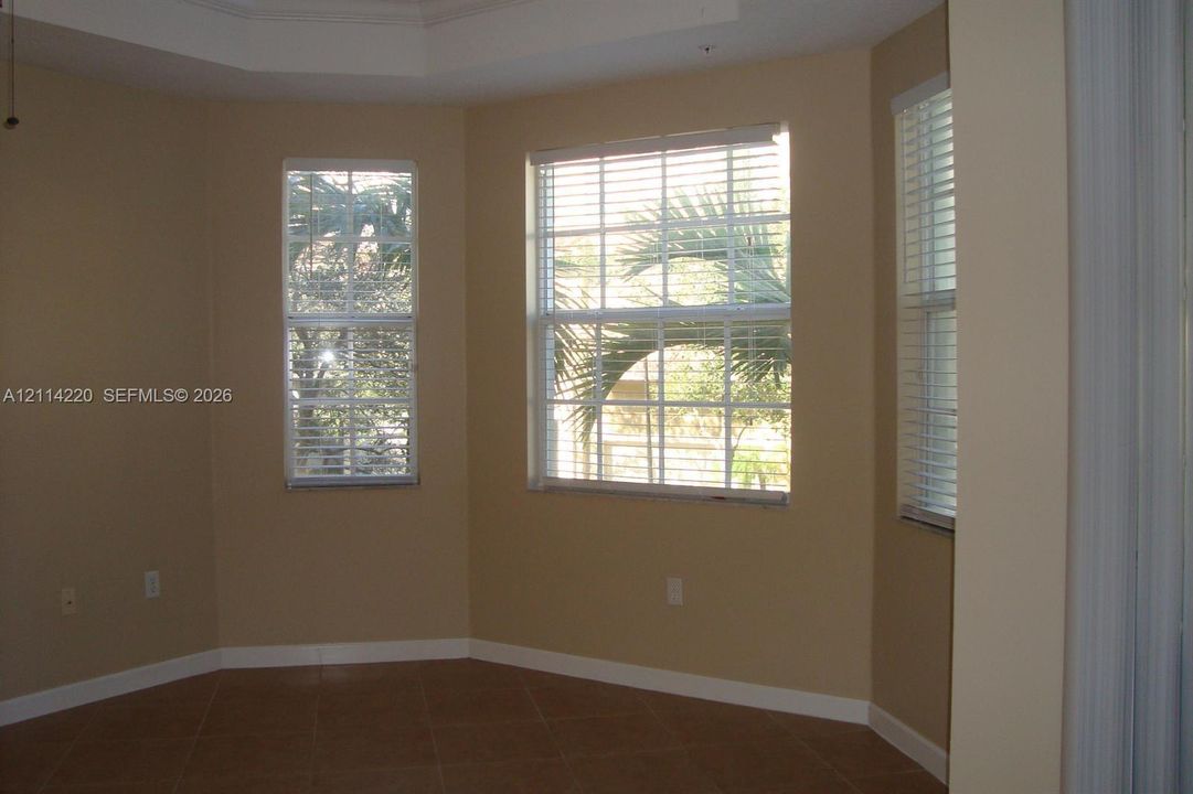 Bay window featuring multi-pane glass, tiled flooring, and a tray ceiling