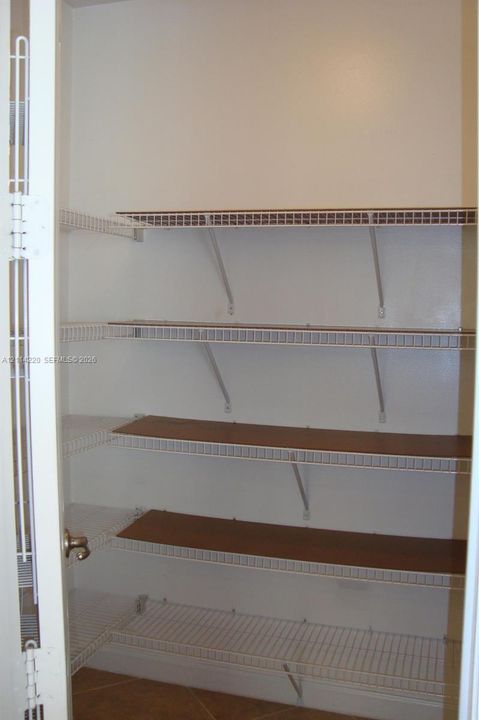 Storage area featuring white wire shelving units and integrated wood-finish shelf inserts