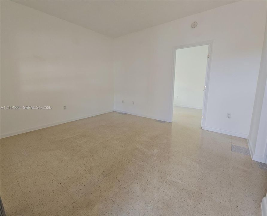 Interior space featuring neutral wall paint, smooth-finish ceiling, and uniform hard-surface flooring