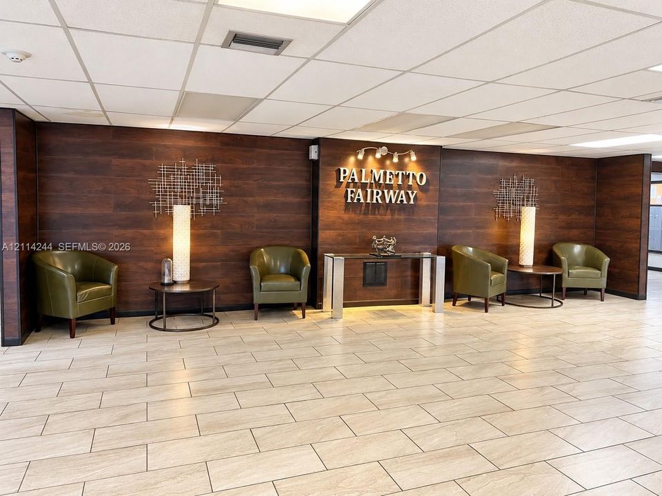 Lobby featuring dark wood-finish wall paneling and tile flooring.