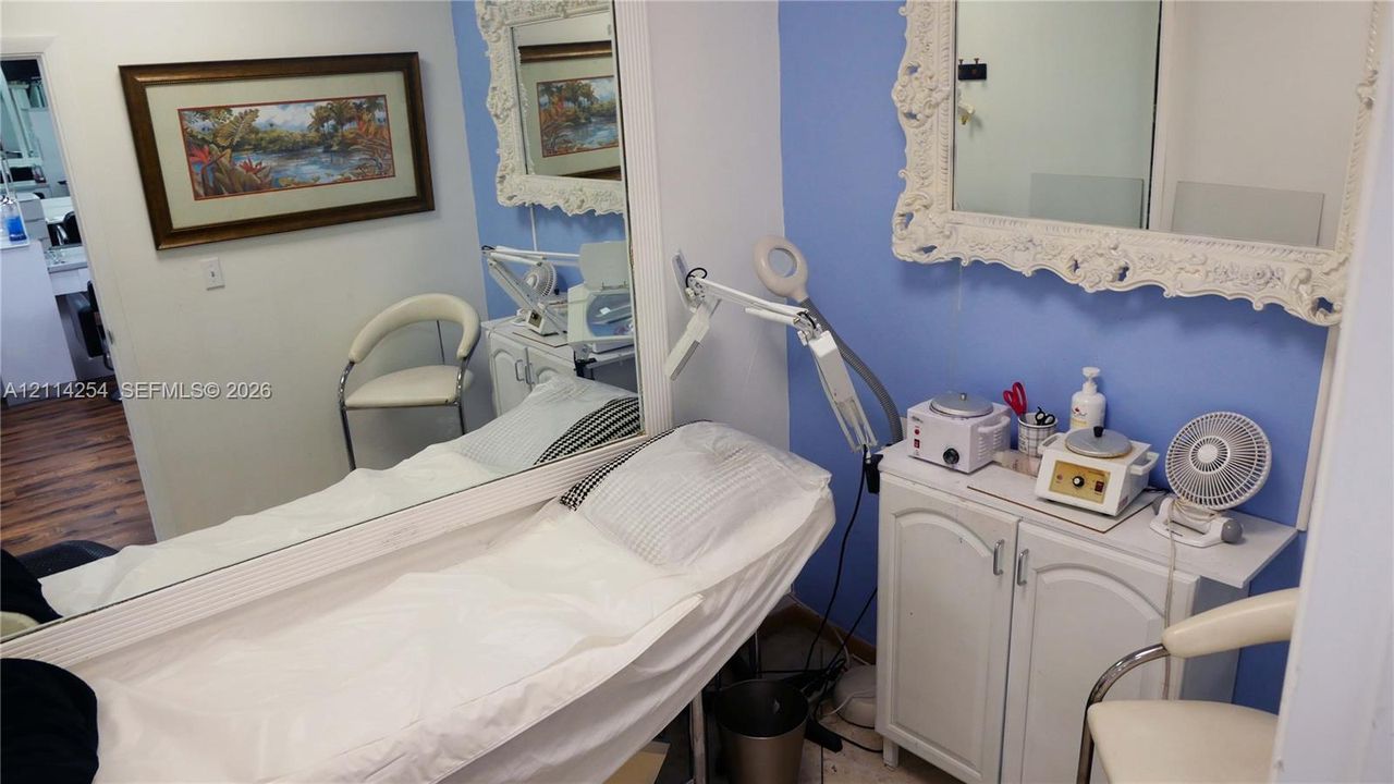Full-length wall mirror with ornate frame, white built-in cabinetry, and wood-finish flooring
