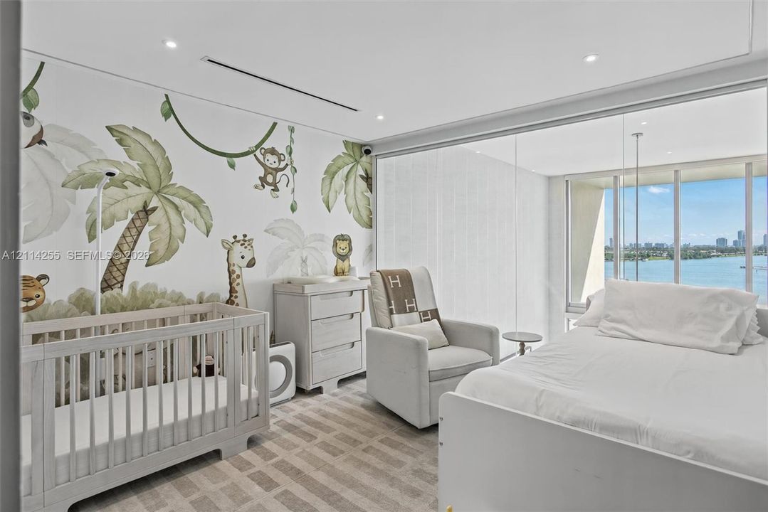 Floor-to-ceiling windows with water backdrop, recessed lighting, and wall-to-wall carpeting