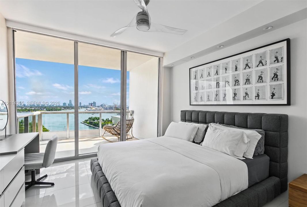 Floor-to-ceiling glass sliding doors, private balcony with glass railing, polished tile flooring, and ceiling fan with integrated lighting