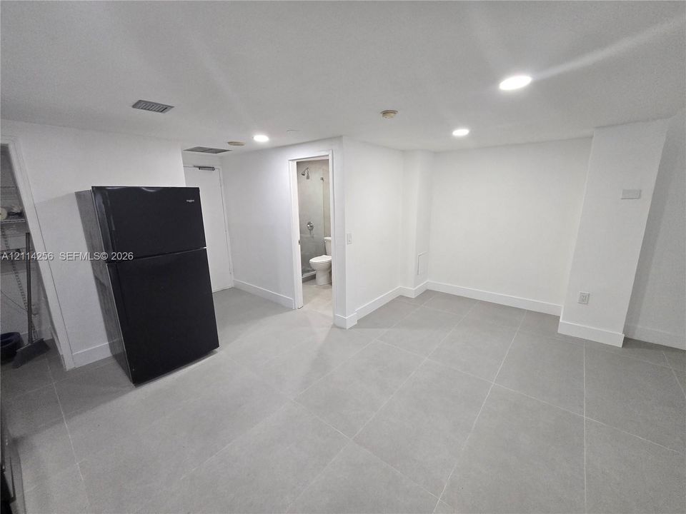 Interior space featuring neutral large-format tile flooring and recessed lighting