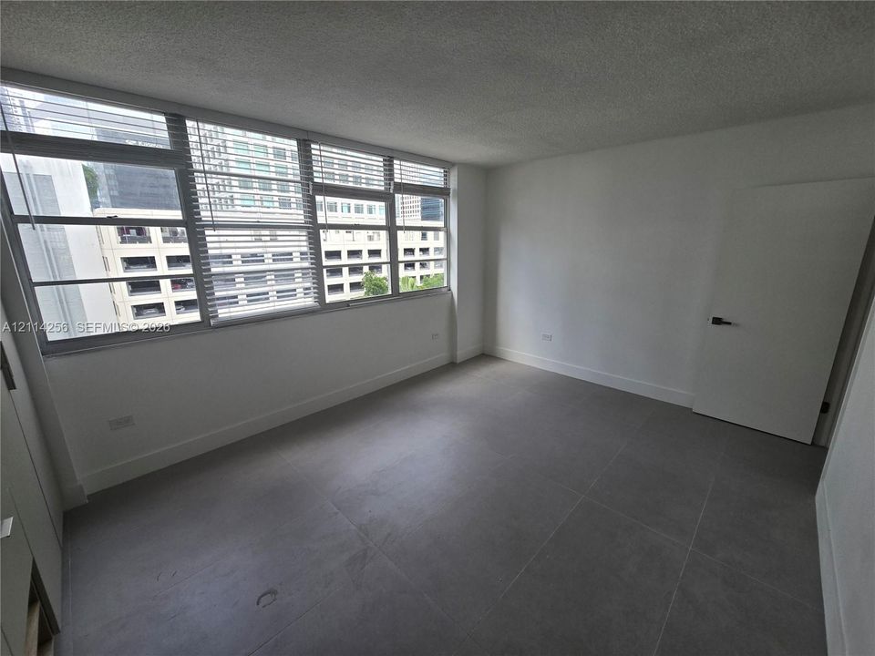 Large multi-pane window assembly, grey oversized tile flooring, and neutral wall finish