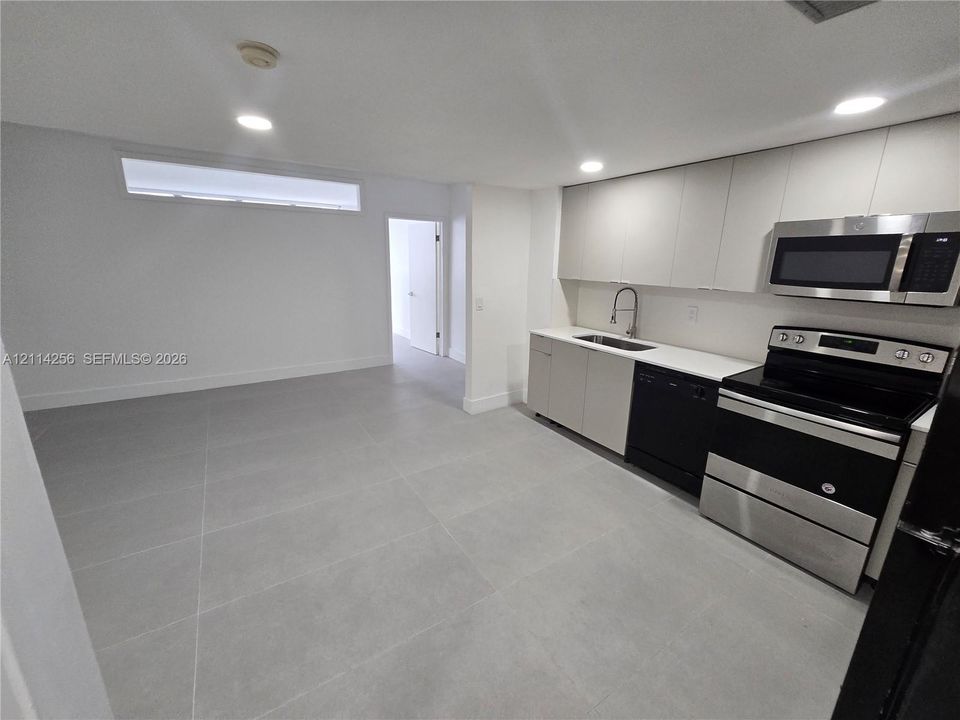 Kitchen featuring flat-panel cabinetry, quartz countertops, tile flooring, recessed lighting, and stainless steel appliances