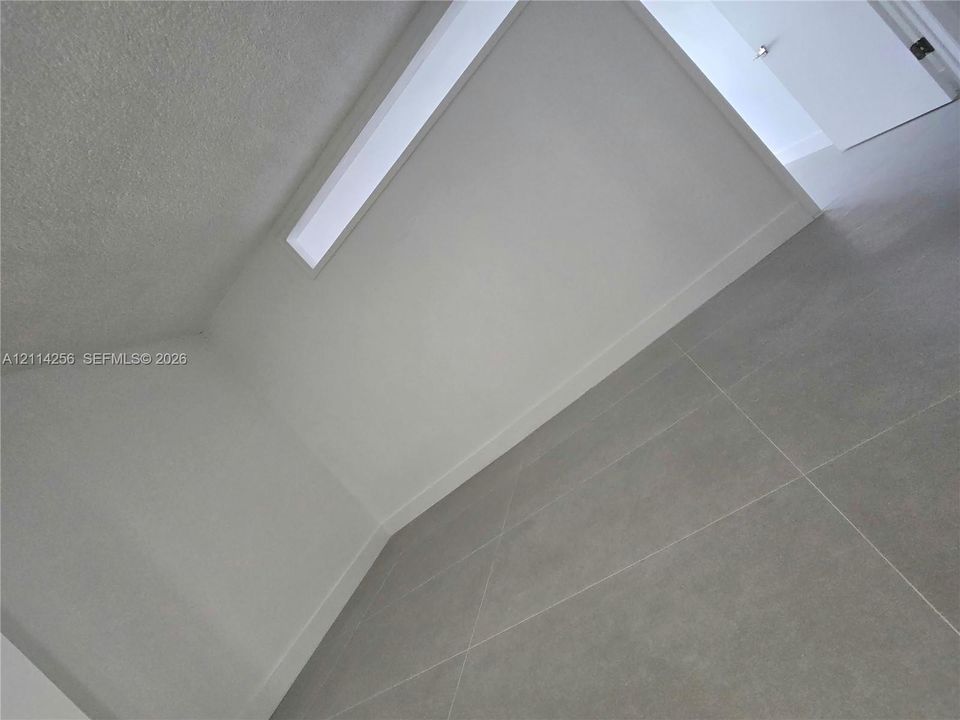 Neutral-toned large-format tile flooring and an integrated skylight