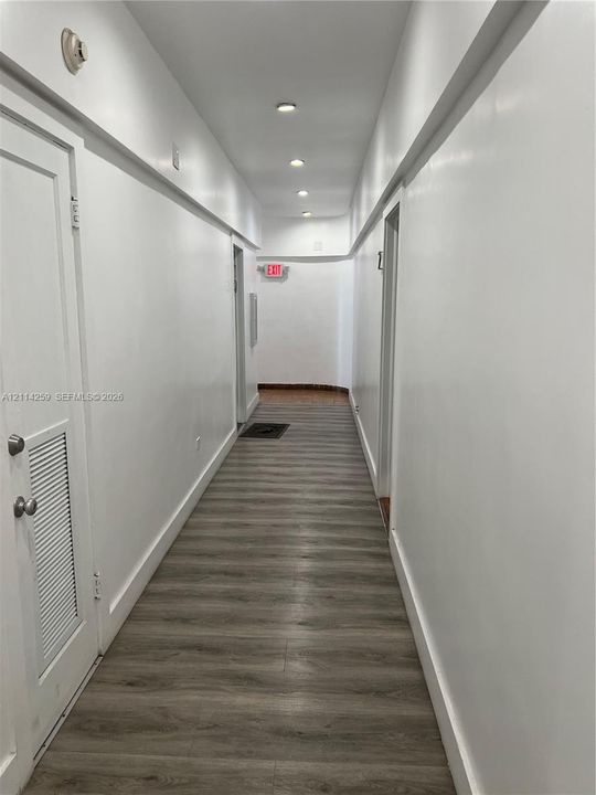 Hallway featuring wood-finish flooring, recessed lighting, and smooth-finish walls