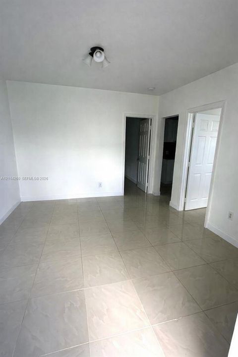 Neutral-toned tile flooring, white interior wall finishes, and multiple six-panel interior doors