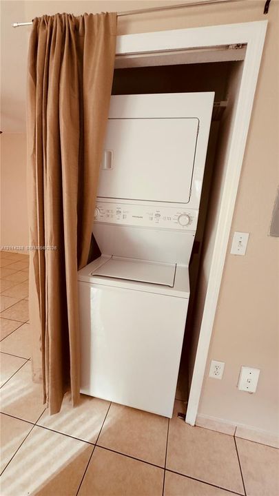 Stacked laundry unit with ceramic tile flooring