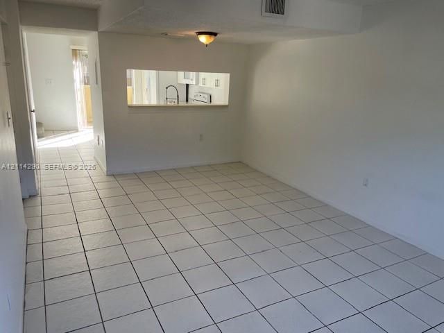 Ceramic tile flooring, kitchen pass-through window, and flush-mount ceiling lighting